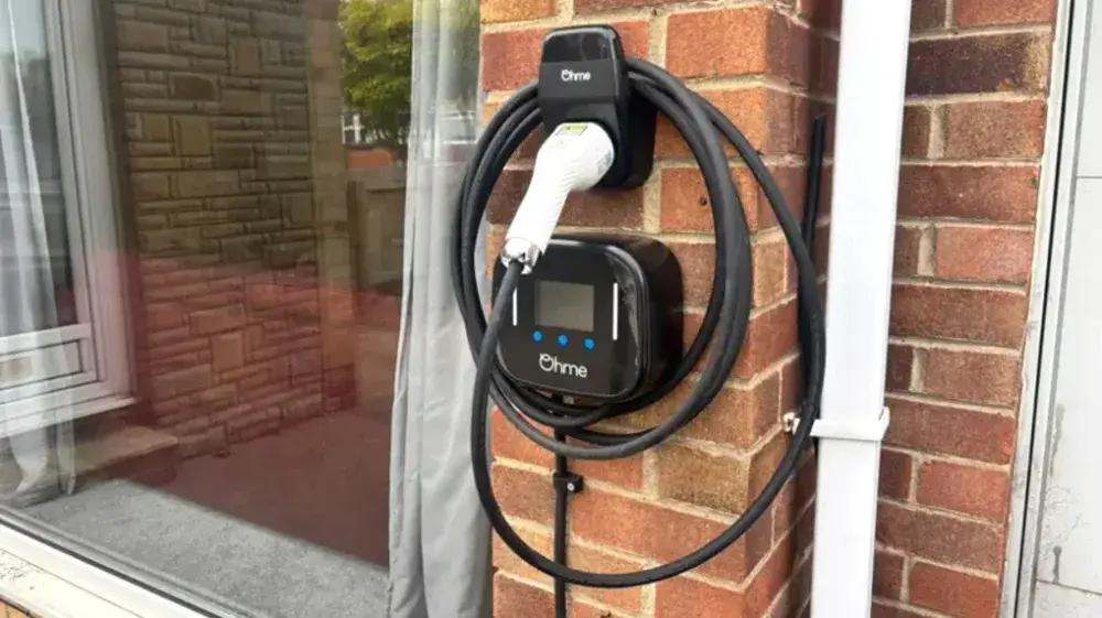 Level 2 EV charger mounted on the brick wall of a home in Gastonia, NC