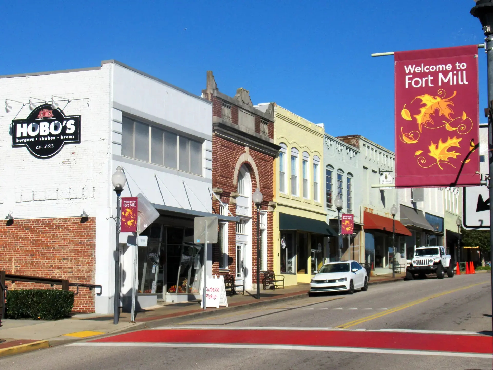 Colorful Main Street storefronts and a Welcome to Fort Mill banner in Fort Mill, SC Colorful Main Street storefronts and a Welcome to Fort Mill banner in Fort Mill, SC